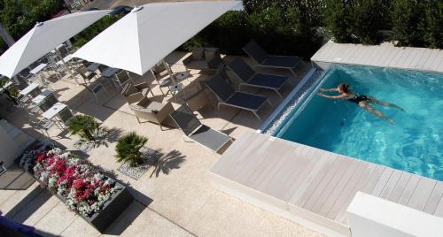 an overhead view of a person swimming in a swimming pool at Hotel Nettuno in Cala Gonone