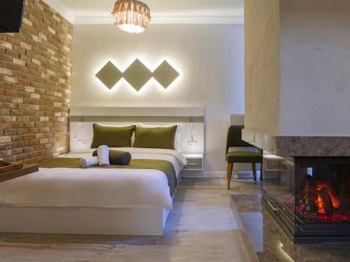 a bedroom with a large bed and a fireplace at Deluna Ümitköy Suite in Çayyolu