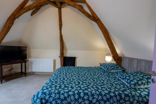 a bedroom with a bed and a flat screen tv at Charmante maison piscine privée in Siorac-en-Périgord