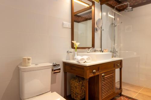 a bathroom with a sink and a toilet and a mirror at Jetwing St Andrew's in Nuwara Eliya