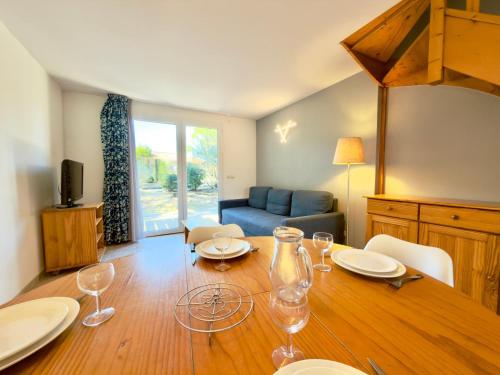 a dining room with a table with wine glasses on it at Les Deux Terrasses, 6 pers Piscine à Calvisson in Calvisson