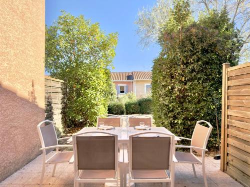 a patio with a table and chairs in a yard at Les Deux Terrasses, 6 pers Piscine à Calvisson in Calvisson
