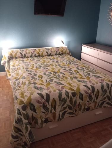 a bed in a bedroom with a comforter on it at petunias in Vic-sur-Cère