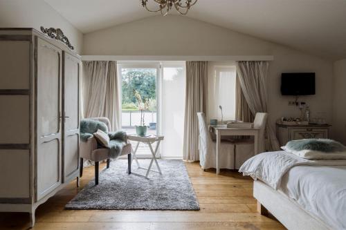 a bedroom with a bed and a desk and a chair at B&B Hof van Vervoering in Voeren