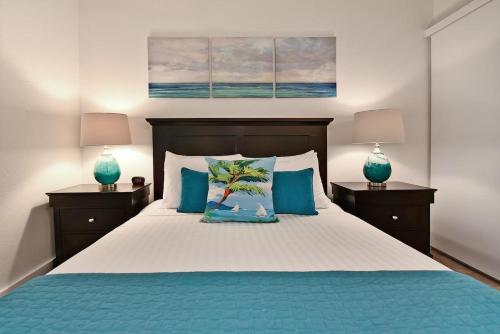 a bedroom with a bed with blue pillows and two lamps at Kihei Alii Kai A207 · KAK A207 Renovated Kihei Condo Near Beach in Kihei