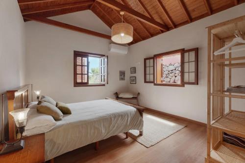 a bedroom with a bed and two windows at Complejo Rural Pajar de Bento in Agulo
