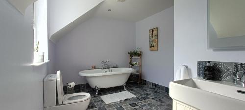a bathroom with a toilet and a tub and a sink at Gateside Lodge in Portrush