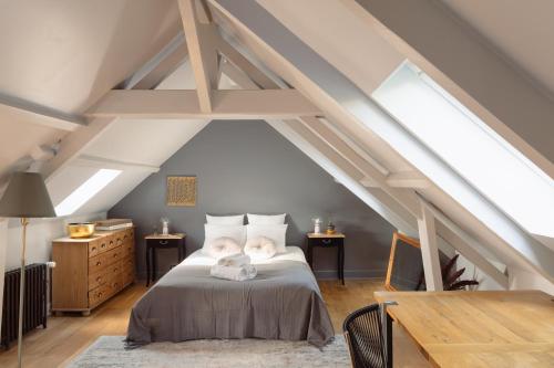 a attic bedroom with a bed and two tables at Cottage Thabor - Centre de Rennes in Rennes