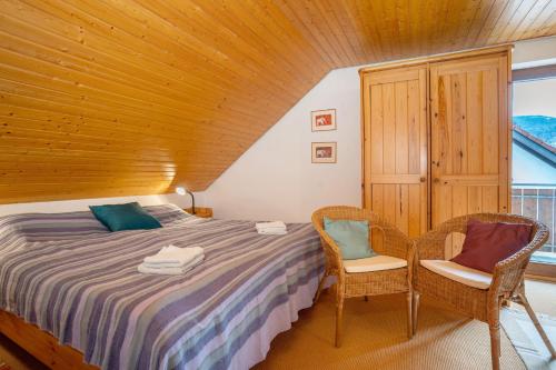 een slaapkamer met een bed en twee stoelen bij Kuckucksnest in Bad Herrenalb