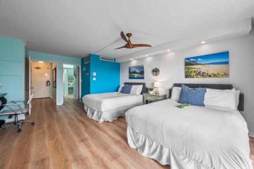カハナにあるEldorado L102 · EL L102 Renovated 1BD Condo w Pool AC Beach Cabaのベッド2台と天井ファン付きの寝室