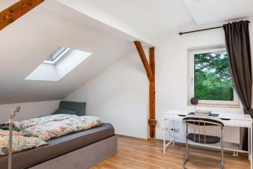 a bedroom with a bed and a desk and a window at Natur pur in Kraiburg am Inn