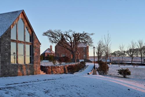 een met sneeuw bedekte straat voor een bakstenen gebouw bij Rachel’s Farm, Glenalmond in Inchture