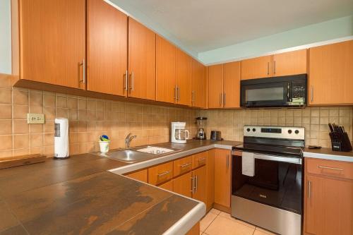 een keuken met houten kasten en roestvrijstalen apparatuur bij Ocean Terrace 202 a 4 min walk to Sandy Beach in Aguada