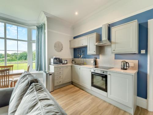 a kitchen with white cabinets and blue walls at Silverdale Apartment in Lindale