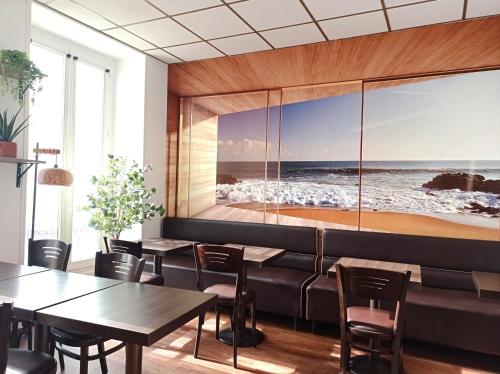 a restaurant with tables and chairs and a picture of the ocean at H33 Hôtel in Nice