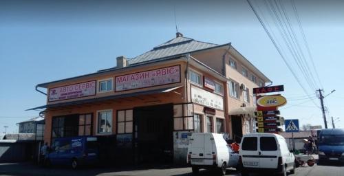 een gebouw met daarvoor geparkeerde auto's bij Явіс in Mamaivci Village