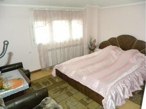 een slaapkamer met een groot bed en een raam bij Явіс in Mamaivci Village