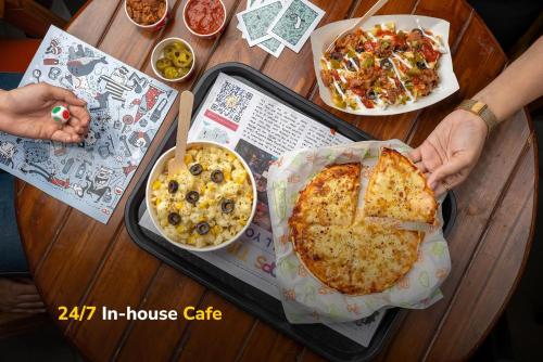a person is holding a pizza on a table at goSTOPS Amritsar, Chatiwind Gate in Amritsar