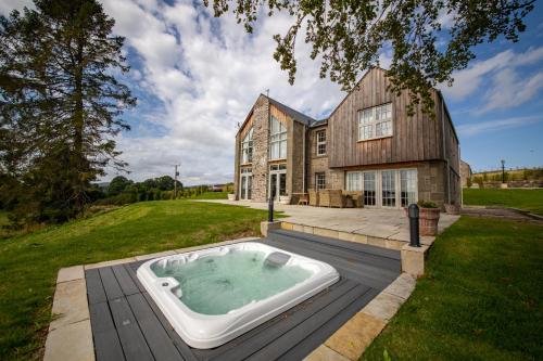 een groot huis met een hottub op een terras bij Rachel’s Farm, Glenalmond in Inchture