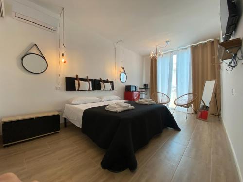 a bedroom with a bed and a table in it at Isid'Oro Rooms - 100m from the sea in Sant'Isidoro