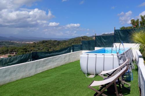 bañera de hidromasaje y silla junto a la piscina en Ca la Nena Morena - Refugio cálido con chimenea y vistas al Montseny, en Vallgorguina