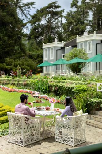 努沃勒埃利耶Jetwing St Andrew's的一男一女坐在桌边