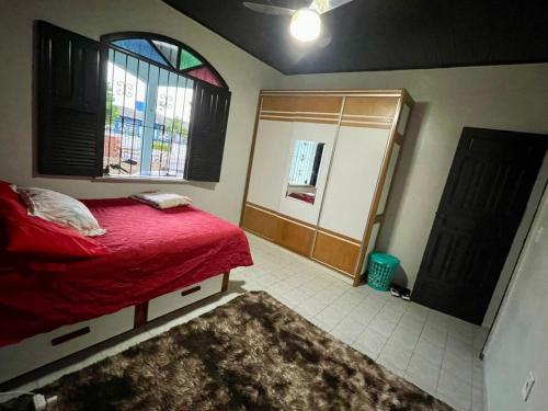 Un dormitorio con una cama roja y una ventana. en Rent cop30 Belém For Mosqueiro Praia Grande, en Belém