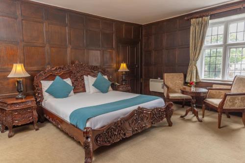 a bedroom with a bed and a table and chairs at Castle Bromwich Hall; Sure Hotel Collection by Best Western in Birmingham