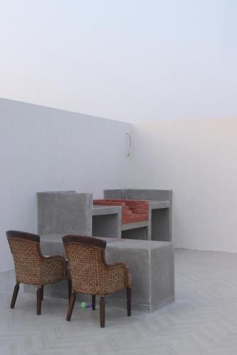 two chairs and a table in a white room at B&B Villa in Ras al Khaimah