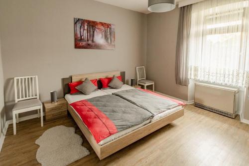 a bedroom with a bed and two chairs and a window at Ferienwohnung Fuchsbau in Neumagen-Dhron