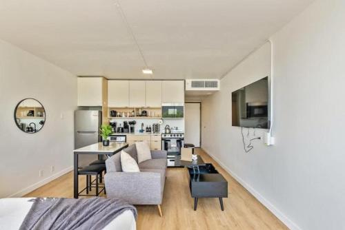 a living room and kitchen with a couch and a table at Cozy DT SLC Studio - 13th Floor Gym - Parking in Salt Lake City