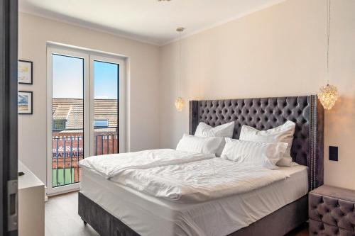 ヴィッテンベルゲにあるElbe6 - 5 Sterne Apartmentsの大きなベッドとバルコニーのある寝室