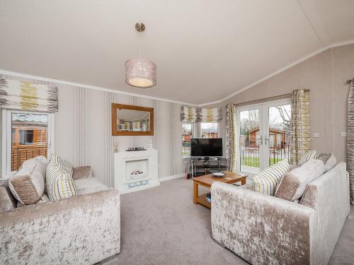 a living room with two couches and a television at Thistle Lodge in Auchterarder