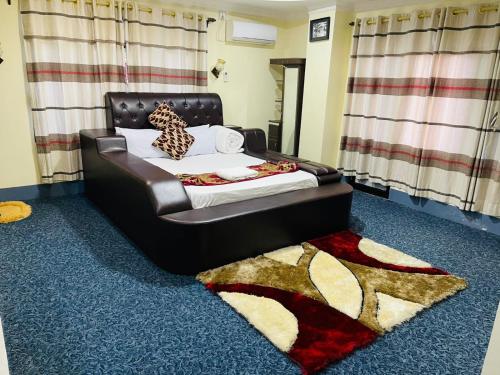 a bedroom with a bed with a black leather headboard at Hotel Green View in Ilām