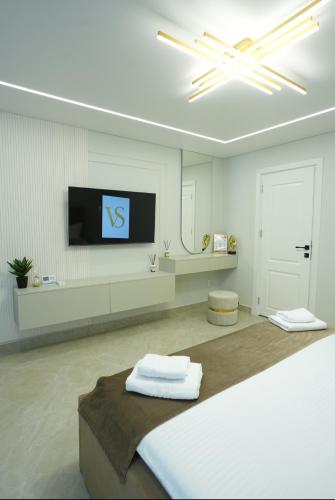 a white room with a bed and a tv on the wall at VS Gold Apartament in Galaţi