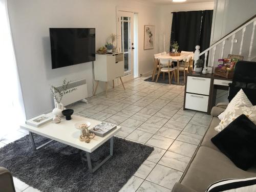 a living room with a couch and a table at Lakeview Modern Home Lake Macquarie Urban Oasis in Toronto