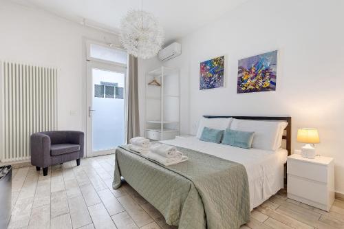 ペスキエーラ・デル・ガルダにあるCamere Amèのベッドと椅子のある白い寝室