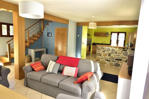 Arras-en-LavedanにあるLe Pircourlet - Haute-Pyrénéesのリビングルーム(赤い枕とグレーのソファ付)