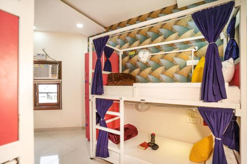 a bedroom with a bunk bed with purple curtains at goSTOPS Amritsar, Golden Temple in Amritsar