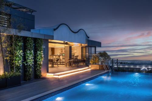a house with a swimming pool at night at Hyatt Place Dhaka Uttara in Dhaka
