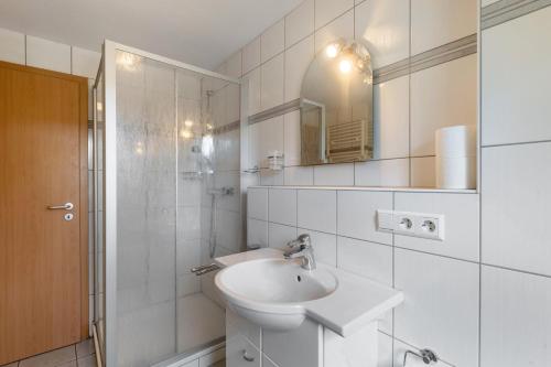 a white bathroom with a sink and a mirror at Ferienwohnung Hacke in Schmallenberg