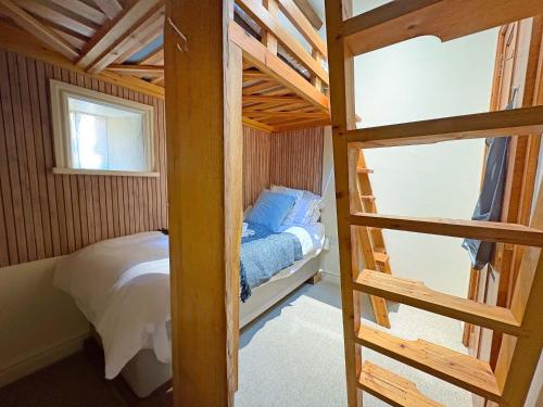 Waltham on the WoldsThe Stables的一间带双层床和梯子的小卧室