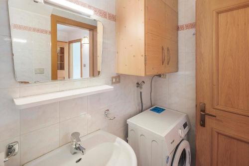 a bathroom with a toilet and a sink and a mirror at Ciasa Lino Rotic in Pozza di Fassa