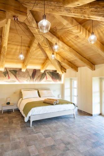 a bedroom with a large bed with wooden ceilings at Bed and Breakfast Cascina Morelli 1862 in Avigliana