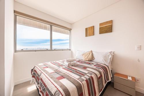 a bedroom with a bed and a large window at Apartamento Moderno Premium - Cittyplex in Osasco