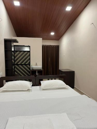 a bedroom with a large bed and a sink at WKND Casa in Panchgani
