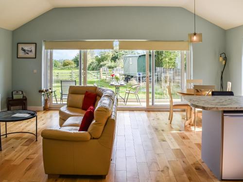 a living room with a couch and a table at Chestnut Lodge in Old Buckenham