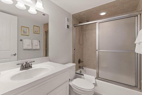 a bathroom with a toilet and a sink and a shower at Beach Club, Unit 134 in East End