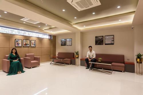a man and a woman sitting in a waiting room at FabHotel Prime Oasis Orange in Bhopal
