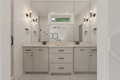 a bathroom with two sinks and a large mirror at Getaway Cottage - 615 Bartow St in Saint Simons Island